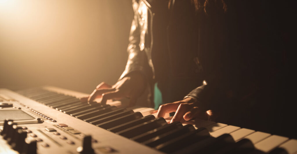 mid section of female musician playing piano in music festival